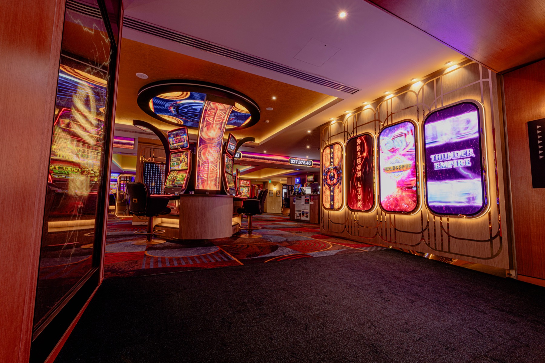 The corridor onto the floor: a central pillar display, a ring display overhead and four arched LED panels along the wall