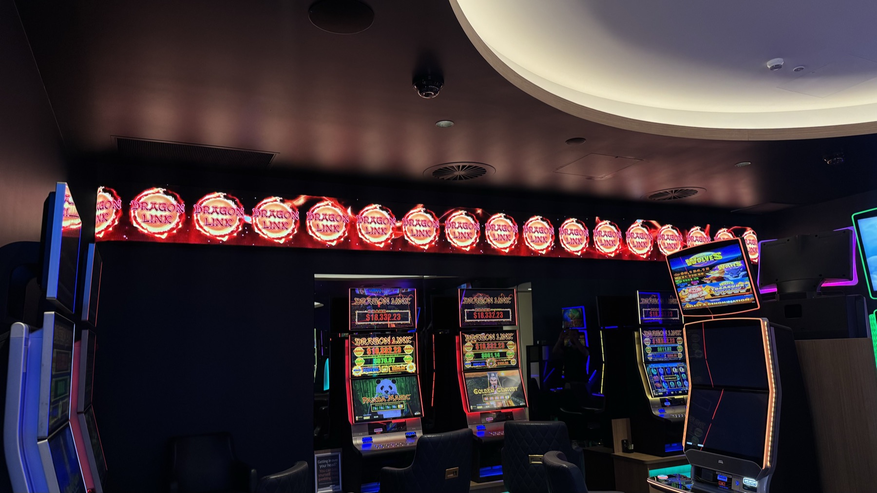 A row of round LED jackpot discs running the length of a bank of machines