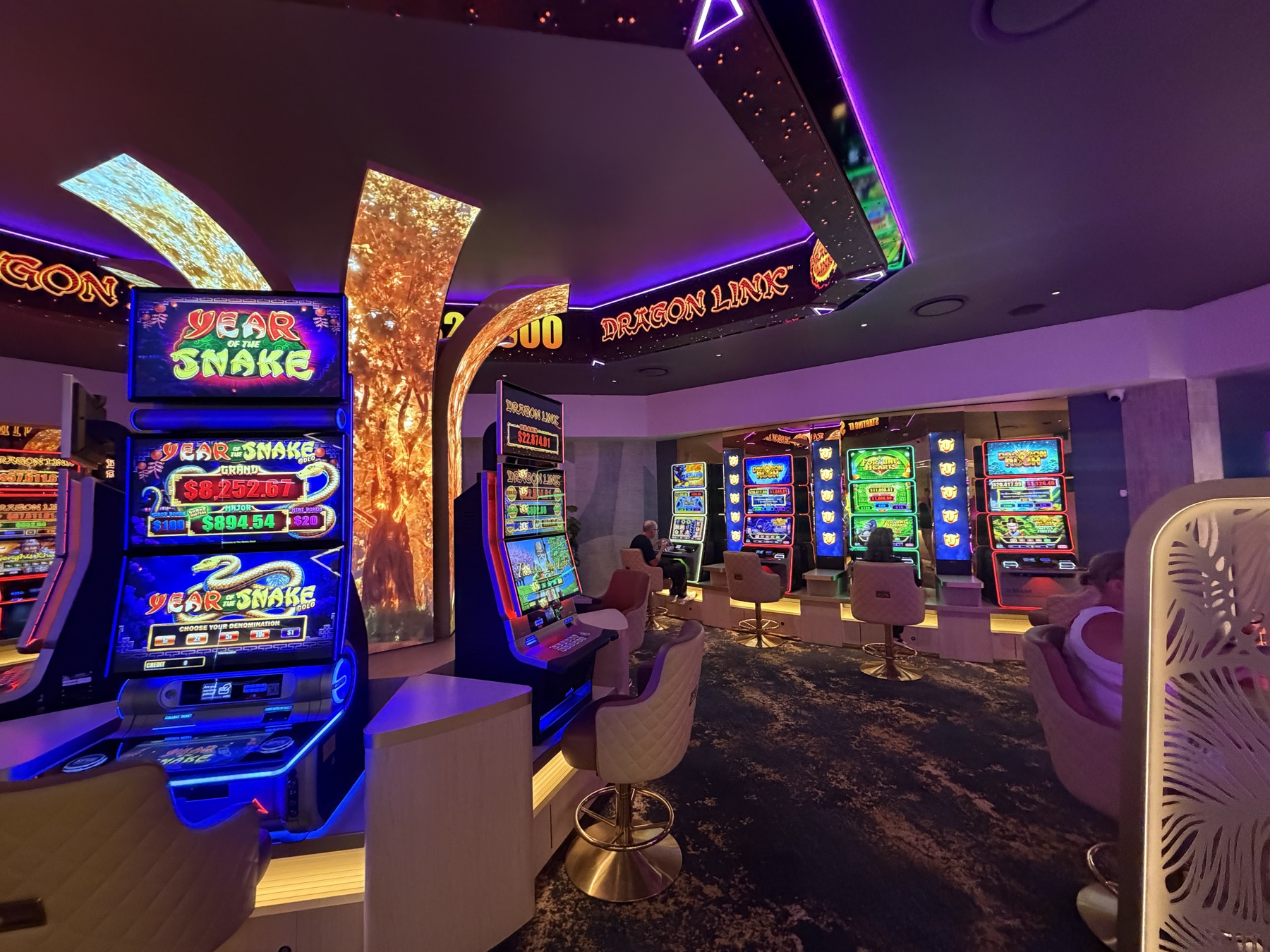 The gaming room with the golden tree column at its centre and LED signage running along the ceiling edge